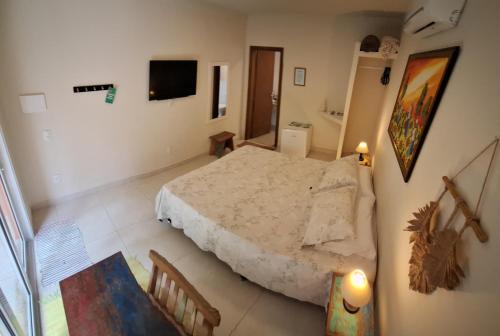 a bedroom with a bed and a television in it at Suítes Cambucá in Ilhabela