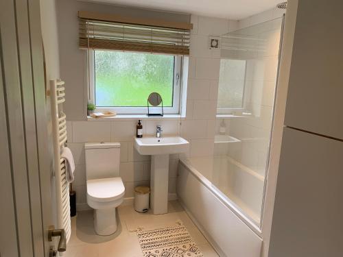 a bathroom with a toilet and a sink and a tub at Bronte Country - 2 Bed Apartment near Cliffe Castle in Keighley