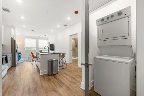 a kitchen with white appliances and a table with chairs at The Nomad ATL in Atlanta
