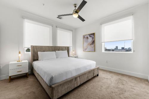 a white bedroom with a bed and two windows at The Nomad ATL in Atlanta