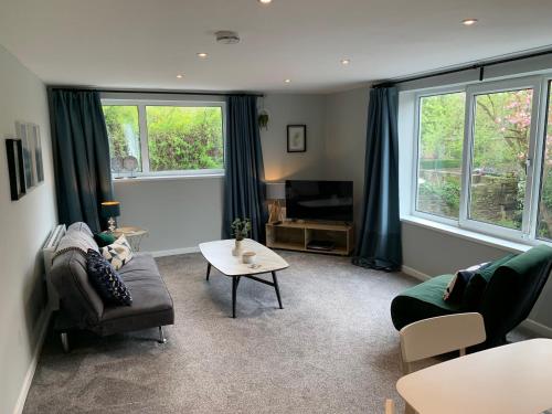 a living room with a couch and a table at Bronte Country - 2 Bed Apartment near Cliffe Castle in Keighley