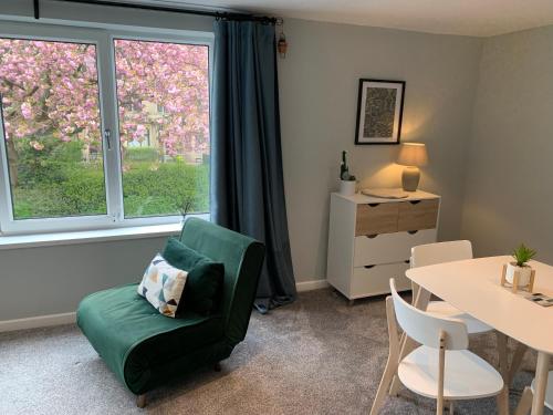 a living room with a green chair and a table at Bronte Country - 2 Bed Apartment near Cliffe Castle in Keighley