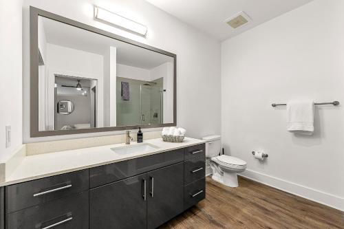 a bathroom with a sink and a toilet and a mirror at The Nomad ATL in Atlanta
