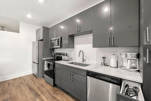 a kitchen with stainless steel appliances and gray cabinets at The Nomad ATL in Atlanta
