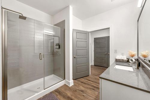 a white bathroom with a shower and a sink at The Nomad ATL in Atlanta