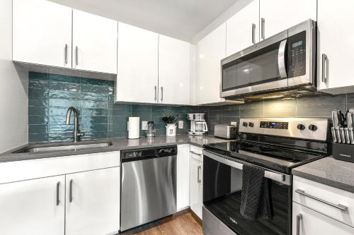 a kitchen with white cabinets and a stove top oven at The Nomad ATL in Atlanta