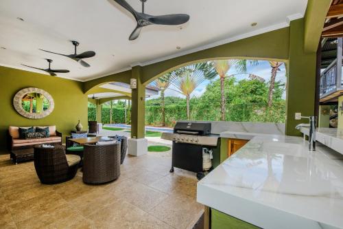 a kitchen and living room with a large window at Villa Encantada By Vacation Pura Vida in Esterillos