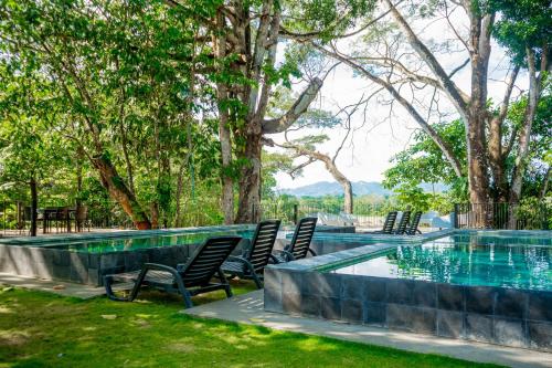 a pool with chairs in a yard with trees at Mistico Serenity Shores at Nautilus in Playa Hermosa