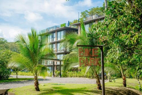 a sign in front of a building with palm trees at Mistico Serenity Shores at Nautilus in Playa Hermosa