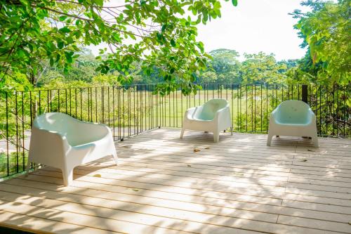 three chairs sitting on a deck with a fence at Mistico Serenity Shores at Nautilus in Playa Hermosa
