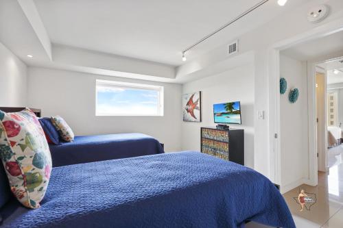 a bedroom with two blue beds and a window at Bahia Mar-Solare Tower, Beachfront Resort with Two Pools in South Padre Island