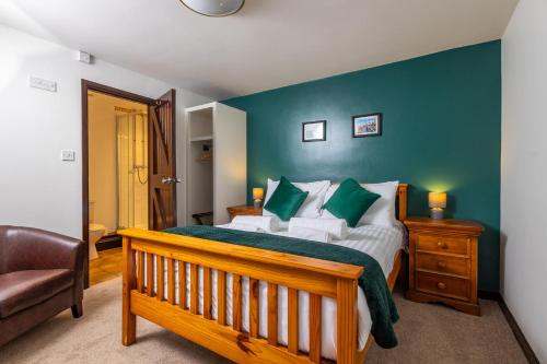 a bedroom with a large bed with green walls at The Black Horse in Swaffham Bulbeck