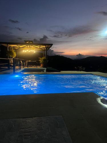 Una gran piscina azul por la noche en Cabañas Alondra, en Vergara