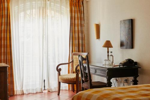 a bedroom with a desk next to a bed and a window at Hotel Peter and Paul, an Ash Hotel in New Orleans