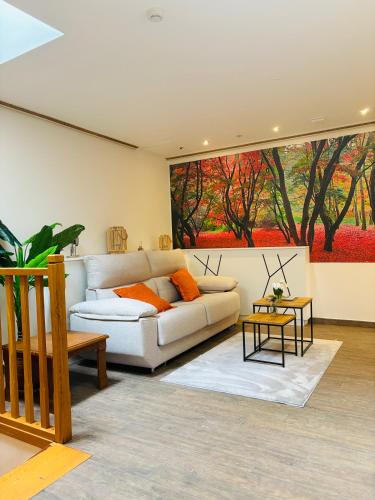 a living room with a white couch and a painting at Oianume in Urnieta