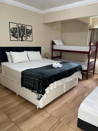 a bedroom with a bed and two bunk beds at Pousada Recanto do Arraial do Cabo in Arraial do Cabo