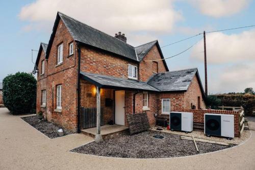 a brick house with two speakers in front of it at Old Town Cottage in Nuneham Courtenay