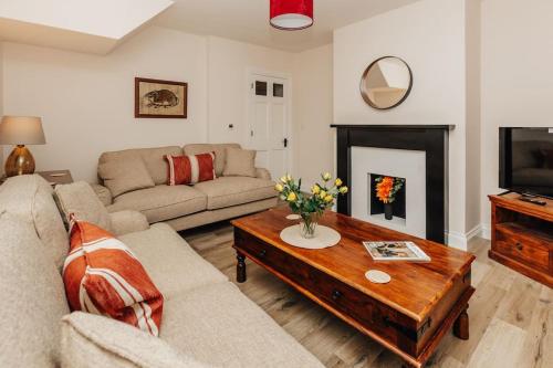 a living room with a couch and a coffee table at Old Town Cottage in Nuneham Courtenay