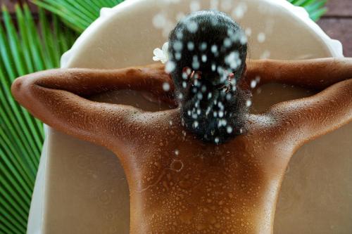 a persons hands holding a black object in water at Hotel Kia Ora Resort & Spa in Avatoru