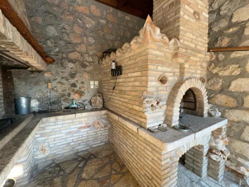 a kitchen with a brick oven in a house at Terra Petra Villa at Psari Trikolonon Gortynia in Psárion