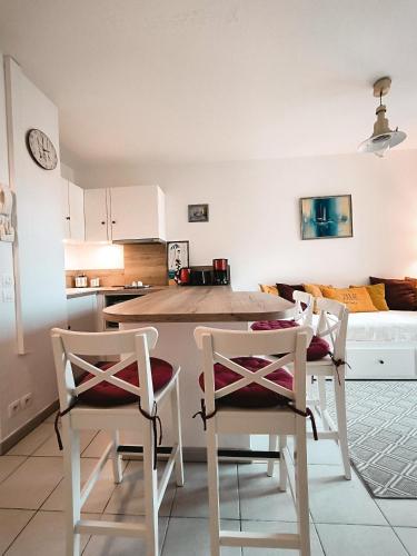 une cuisine et une salle à manger avec une table et des chaises dans l'établissement Mon nid soulacais - Parking Privée, à Soulac-sur-Mer