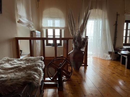 a room with a wheel and a vase on a wooden floor at Terra Petra Villa at Psari Trikolonon Gortynia in Psárion