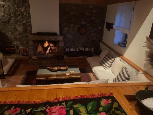 a living room with a fireplace and a couch at Terra Petra Villa at Psari Trikolonon Gortynia in Psárion