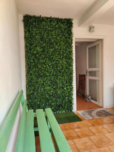 a green wall with a green bench in front of it at Bed&Breakfast Angela in Clusone