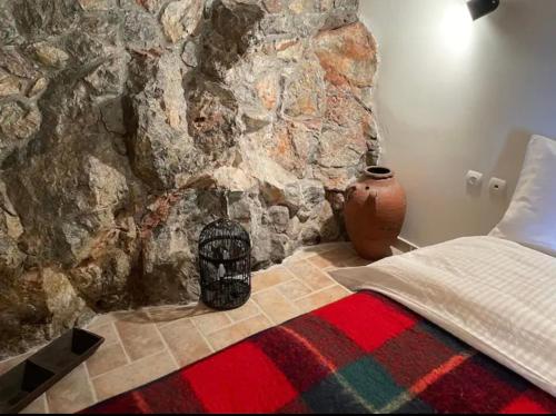 a bedroom with a stone wall with a bird cage at Terra Petra Villa at Psari Trikolonon Gortynia in Psárion