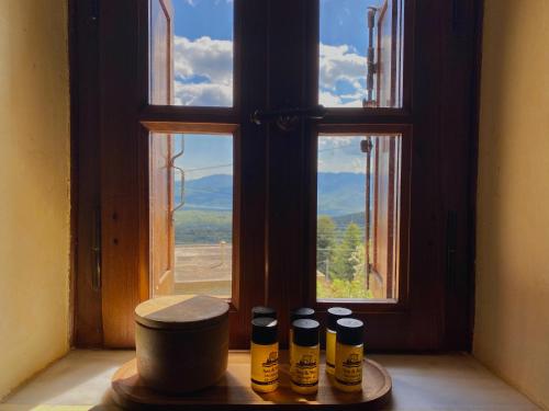 a group of bottles sitting on a table in front of a window at Terra Petra Villa at Psari Trikolonon Gortynia in Psárion