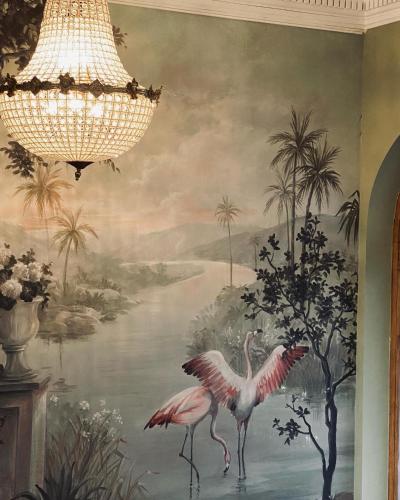 a painting of flamingos on a wall with a chandelier at La Villa Barbieux in Roubaix
