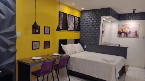 a bedroom with a bed and a table and chairs at Studio Pelourinho, Salvador in Salvador