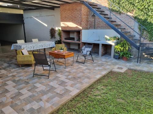 a patio with chairs and a table and stairs at La Casa del Viajero in Roque Sáenz Peña