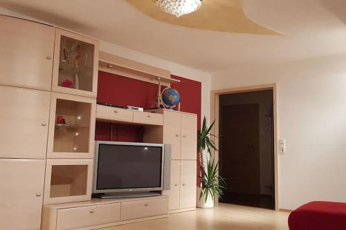 a living room with a flat screen tv in a cabinet at Geräumige 2-Zimmerwohnung in ruhiger Lage in Ansbach