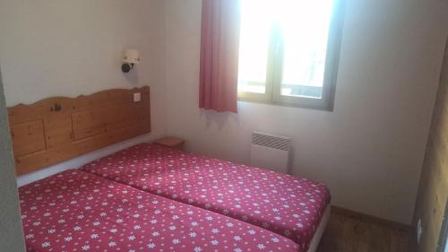 - une chambre avec un lit doté d'un couvre-lit rose et d'une fenêtre dans l'établissement Résidence Hameau Des Ecrins - HEA405 - APPARTEMENT 1 CHAMBRE MAE-1811, à Narreyroux