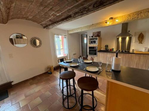 une cuisine avec une table et des tabourets dans une pièce dans l'établissement La casa terracotta, à Claira