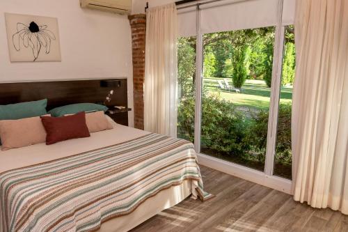 a bedroom with a bed and a large window at Finca El Amparo in Los Reartes