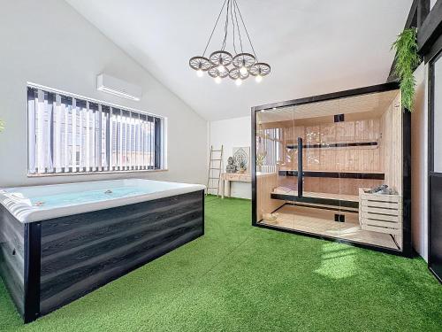 Cette chambre dispose d'une baignoire et d'une moquette verte. dans l'établissement LOFT SPA SAUNA 10 personnes Centre ville, à Montluçon