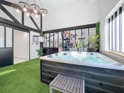 bañera grande en una habitación con suelo verde en LOFT SPA SAUNA 10 personnes Centre ville, en Montluçon