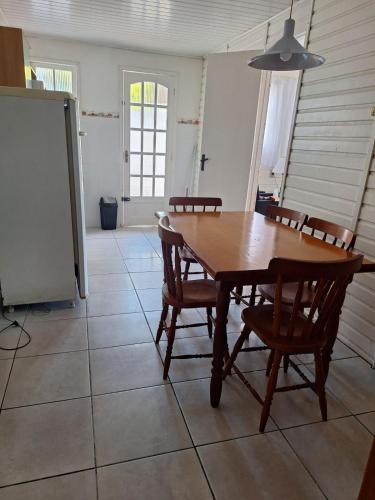 a dining room with a wooden table and chairs at Casinha Cinza Cassino in Rio Grande