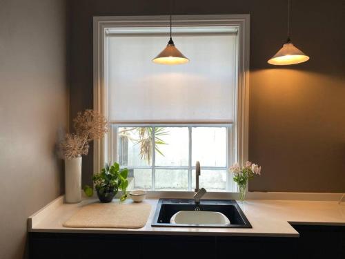a kitchen with a sink and a window at The Georgian Apartment in Worthing