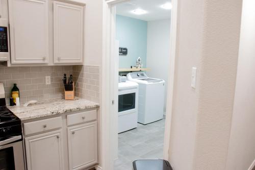 a kitchen with white cabinets and a white appliances at Texas Roots: King Beds and Modern Comfort in McKinney