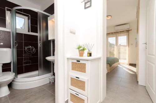 une salle de bains avec douche, toilettes et lavabo dans l'établissement Apartments Sunny Corner, à Tribunj