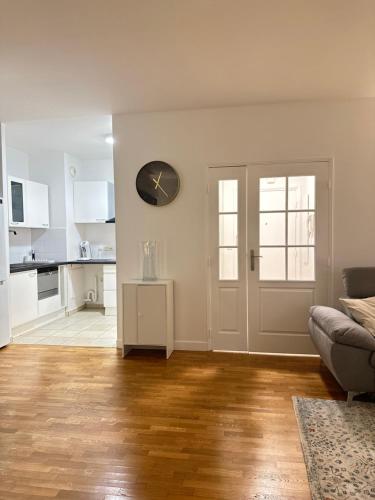 un salon avec un canapé et une horloge au mur dans l'établissement Appartement 2 pièces Paris près du Canal St-Martin, à Paris