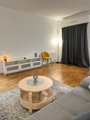 un salon avec un canapé et une table dans l'établissement Appartement 2 pièces Paris près du Canal St-Martin, à Paris