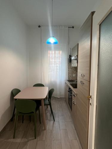 cocina con mesa, sillas y luz azul en Apartament Perła, en Milán
