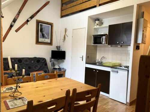 Il comprend une cuisine et une salle à manger avec une table en bois. dans l'établissement Résidence Comete - Studio 4 couchages bien situé dans la station de Reallon 445C MAE-8891, à Réallon