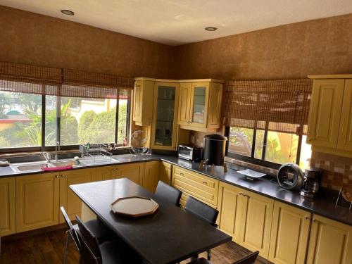 a kitchen with yellow cabinets and a table in it at Casa Pino Residencia de Lujo - Alberca con Caldera Incluido in Cuernavaca