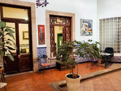 a room with two doors and chairs and plants at Villa Catrina in Morelia