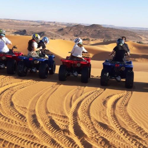 a group of people riding on atvs in the desert at Merzouga Horizon Luxury Camp in Merzouga